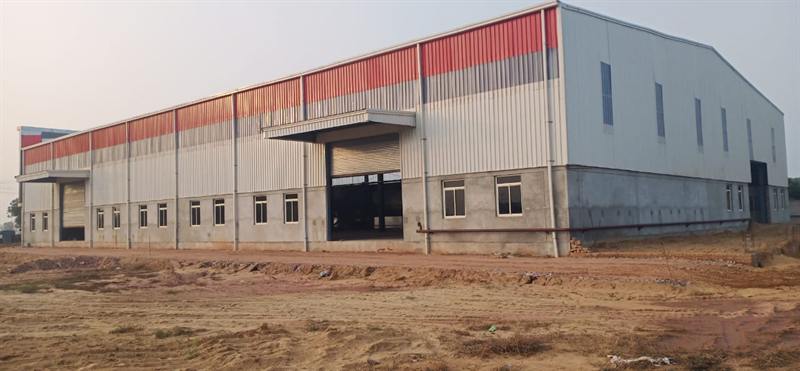 Red-roofed industrial building with a long front elevation